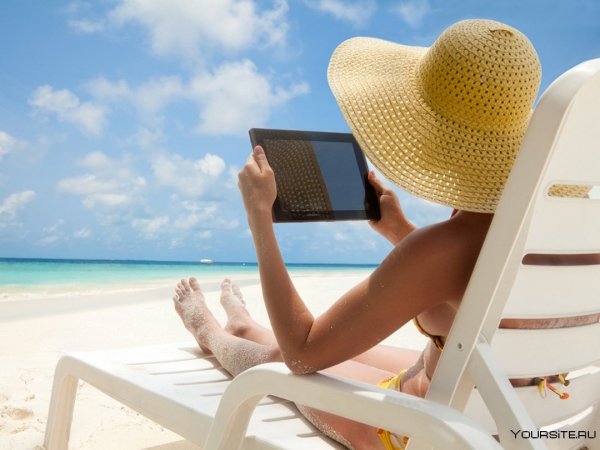 Девушка с ноутбуком на берегу моря