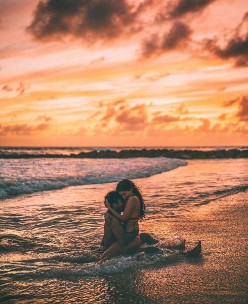 Пара на берегу на закате