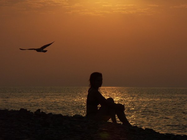 Девушка сидит у моря