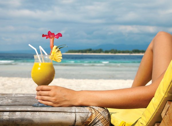 Девушка с коктейлем на пляже