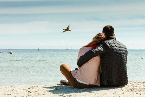 Двое влюбленных сидят на берегу