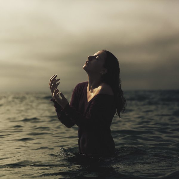 Девушка сидит на берегу моря