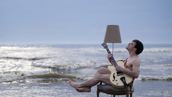 Парень с гитарой у моря