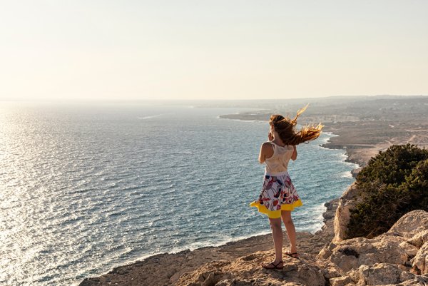 Девушка на скале у моря