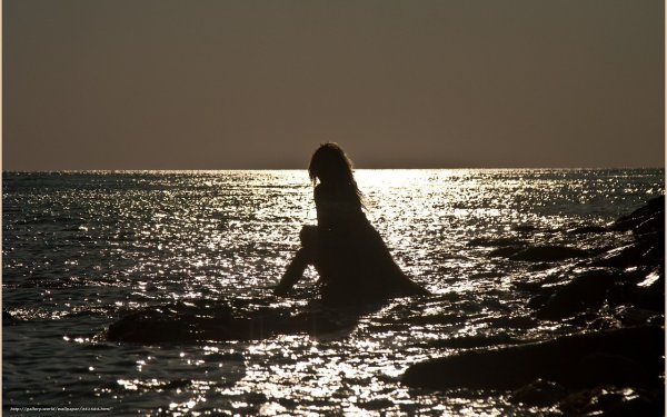 Девушка с ноутбуком на берегу моря