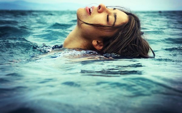 Девушка ныряет в бассейн