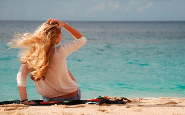 Девушка блондинка со спины на море