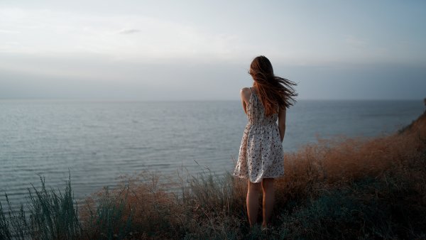 Девушка сидит на берегу моря
