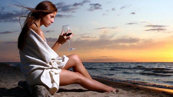 Девушка с бокалом на море