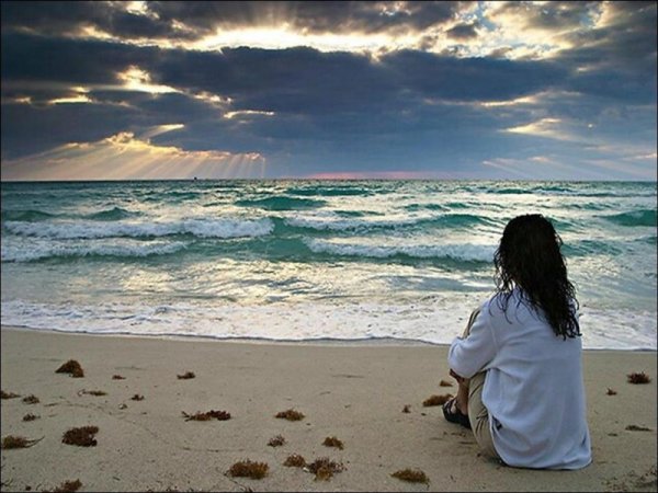 Девушка у моря грустит