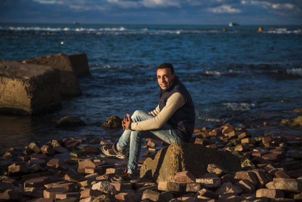 Человек сидит на берегу моря