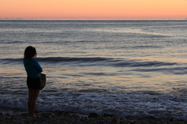 Девушка на берегу моря на закате