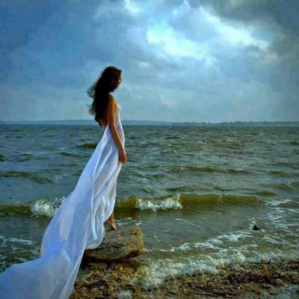Девушка в длинном платье у моря