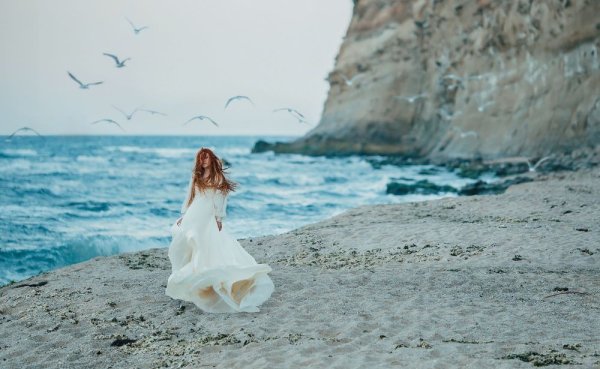 Девушка в длинном платье у моря