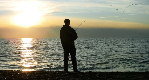 Мужики рыбачат на берегу моря