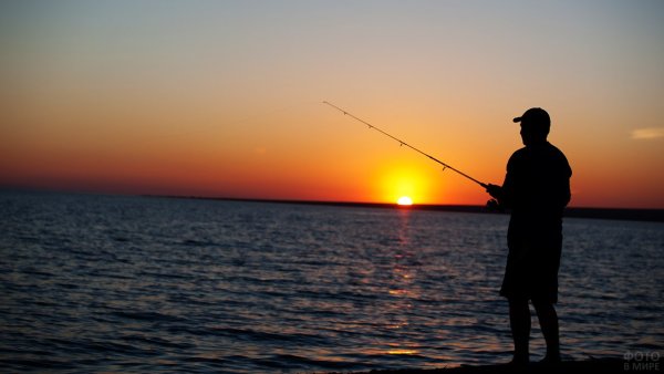Рыбак в лодке на закате