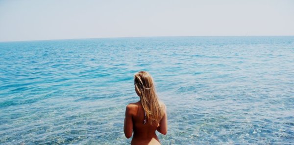 Блондинка на фоне моря со спины