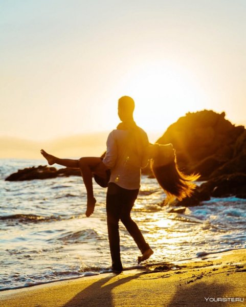 Влюбленные обнимаются на берегу моря