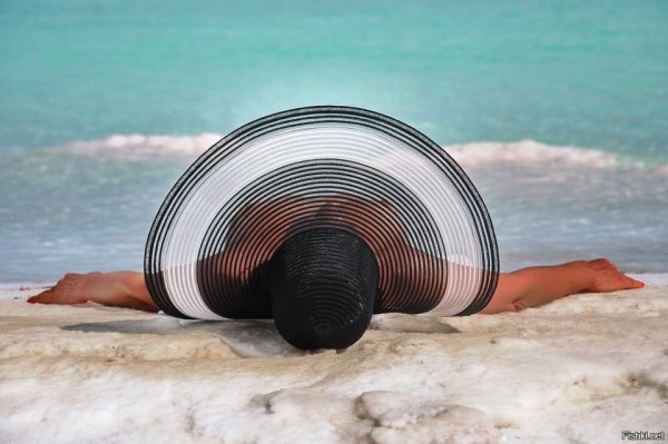 Девушка в большой шляпе на море