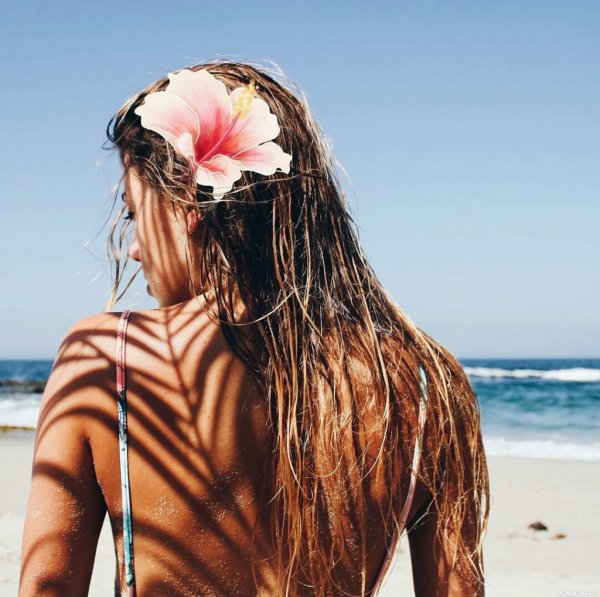 Девушка с цветами в волосах на пляже