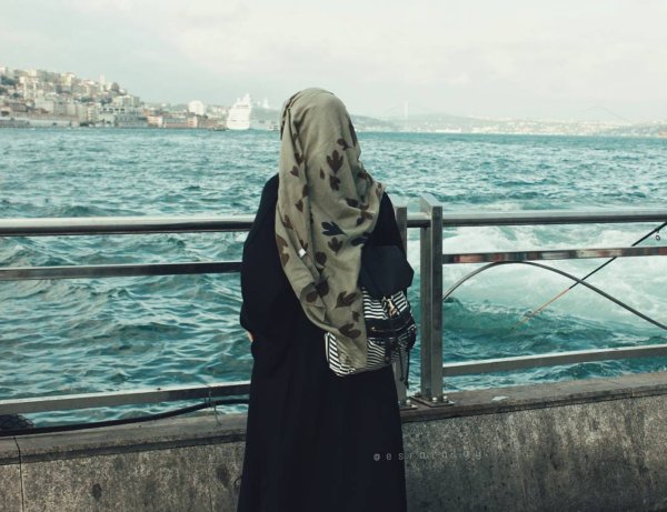 Девушка в хиджабе со спины на закате с рюкзаком