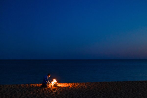 Костер на берегу моря ночью