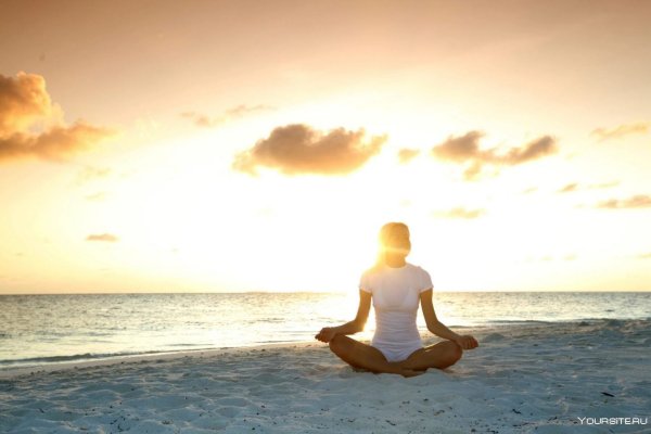 Девушка медитирует на берегу