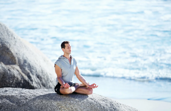 Девушка медитирует на берегу