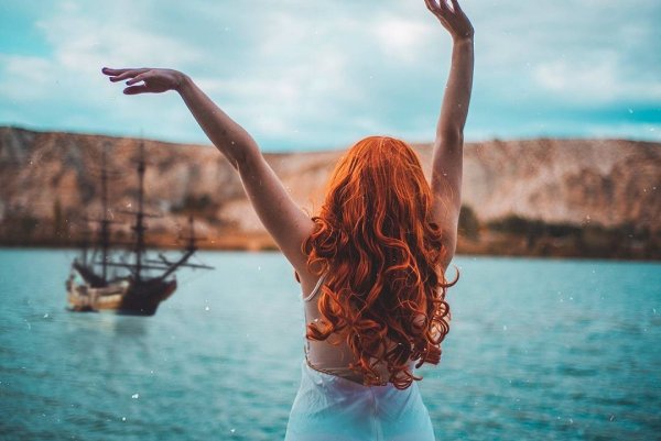 Рыжеволосая девушка на море