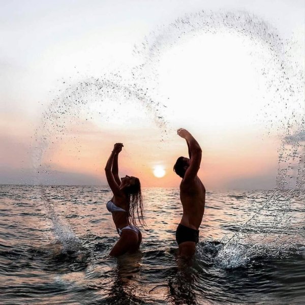 Мужчина дарит цветы женщине на берегу моря