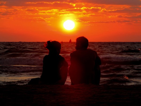 Пара на берегу моря на закате