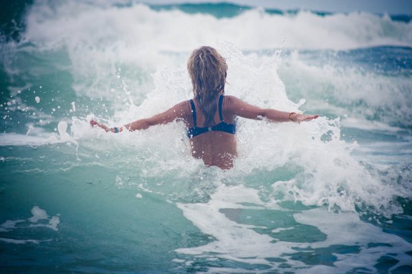 Девушка купается в море