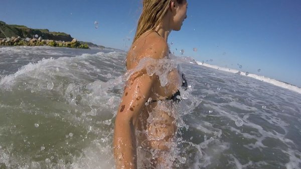 Девушка купается в море