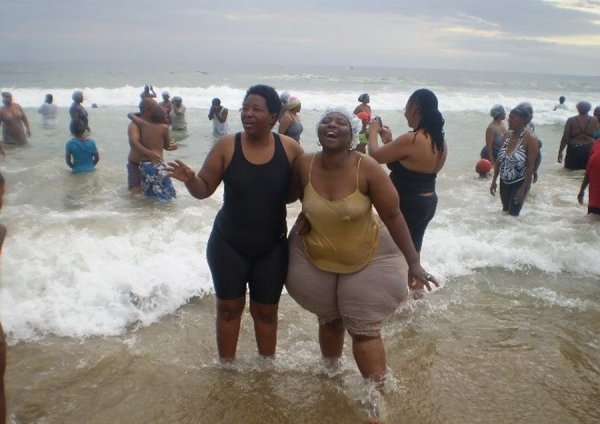 Полные люди на пляже