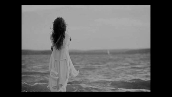 Девушка грустит на берегу моря