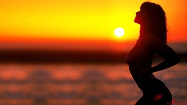 Девушка лежит на песке у моря