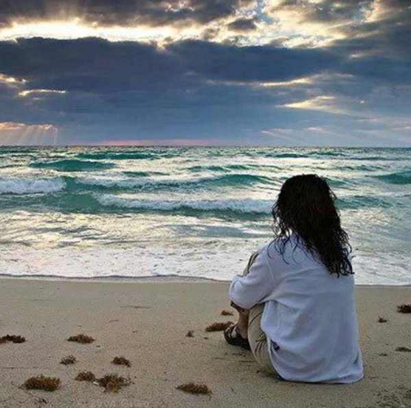 Черноволосая девушка со спины на море