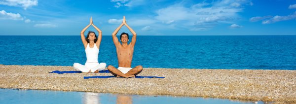 Девушка медитирует на берегу