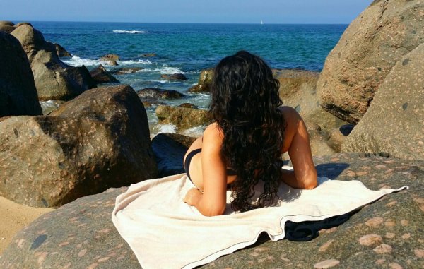 Брюнетка на море со спины