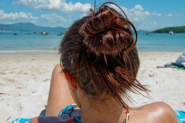 Брюнетка на море со спины