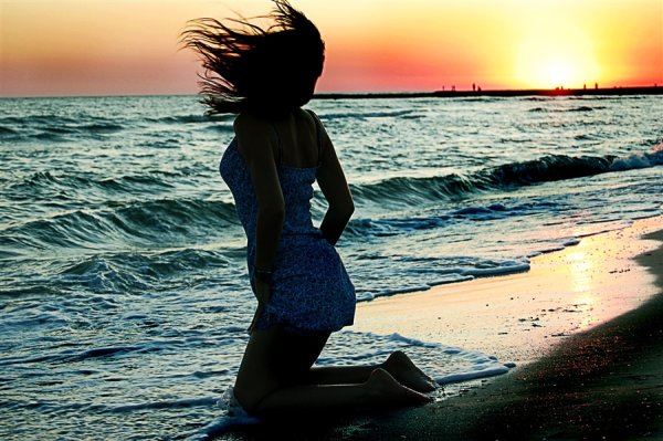 Брюнетка на море со спины