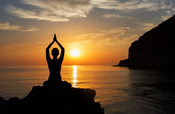 Девушка медитирует на берегу моря