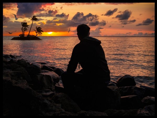 Человек молится на берегу моря