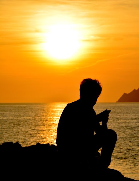 Человек сидит на берегу моря