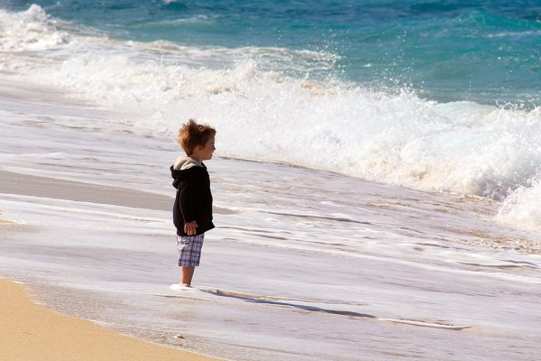 Парень сидит на берегу моря