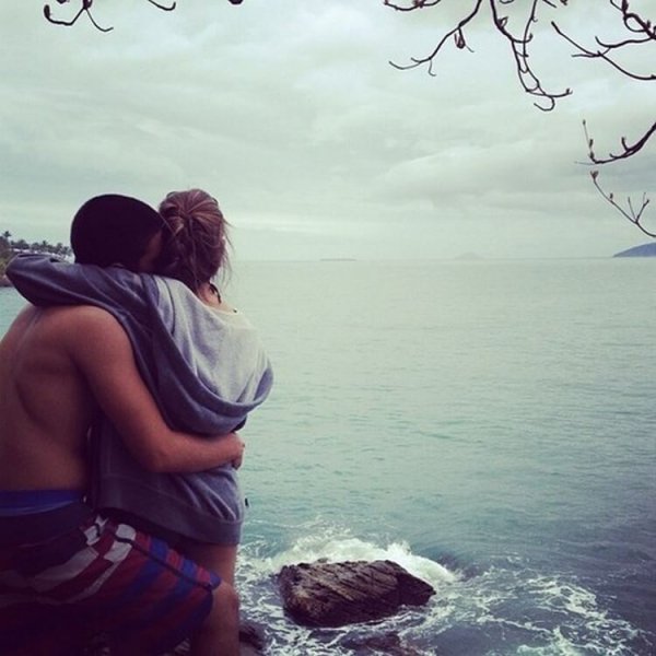 Парень обнимает девушку на море