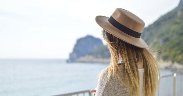 Девушка в шляпе с бокалом на пляже