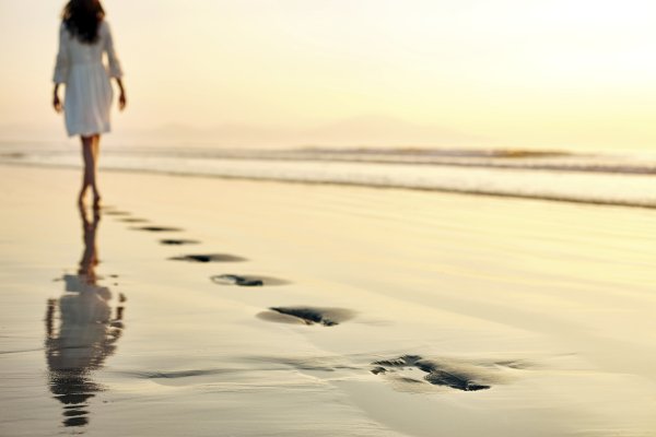 Девушка идет по песку