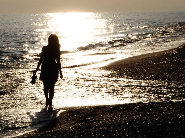 Женщина идет по берегу моря