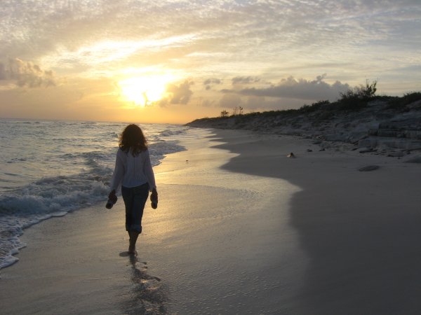 Человек идет по берегу моря